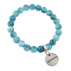 Blue beaded bracelet with a 'GRATEFUL' charm on a white background