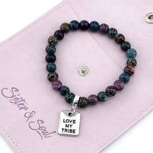 Multicolored beaded bracelet with 'Love My Tribe' charm on a pink card with 'Sister & Soul' branding.