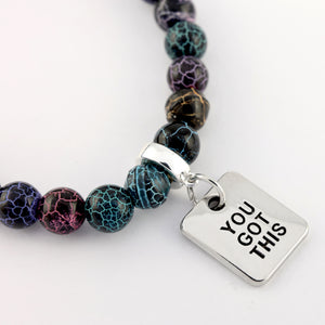 Bracelet with marbled beads and 'YOU GOT THIS' charm on a white background