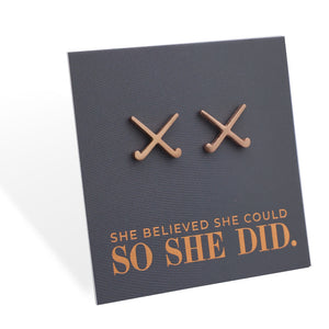 Pair of hockey shaped earrings on a card with 'She believed she could so she did' text