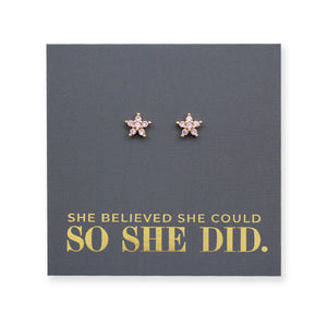 Pink cubic zirconia star shaped studs presented on a grey card with gold 'She Believed She Could So She Did' writing.