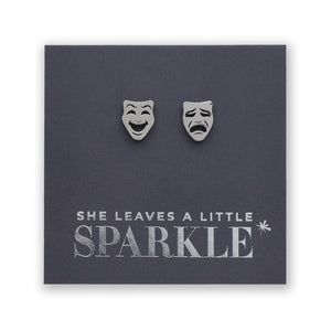 Earrings shaped like comedy and tragedy masks on a card with 'She Leaves a Little Sparkle' text.