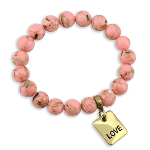Pink beaded bracelet with a gold 'LOVE' charm on a white background