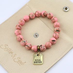 Pink beaded bracelet with 'Soul Sister' charm on an oat pouch