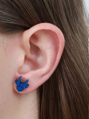 Love Just For You reindeer acrylic glitter stud earrings in dark blue glitter worn on an ear to show size and fit