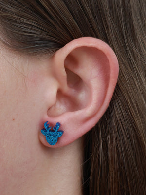 Wishing You Joy reindeer acrylic glitter stud earrings in aqua blue glitter worn on an ear to show size and fit