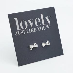 silver bows on a grey card that says "lovely just like you" on a white