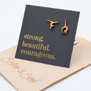 Gold stainless steel gymnastics earring set on a black card with 'strong. beautiful. courageous.' text, displayed on a beige gift pouch.