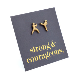 gold Martial Art Studs on a grey card that says "strong & courageous" in gold writing, on a white background.