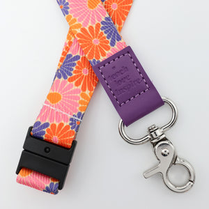 Floral lanyard with purple tag and silver clip on a white background