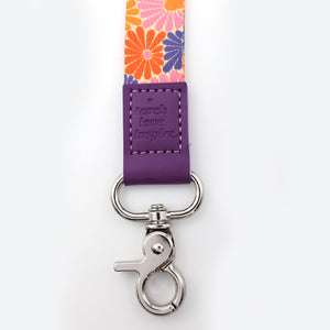 Floral lanyard with purple tag and metal clip on a white background