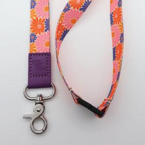 Floral lanyard with a purple strap and metal clip on a white background