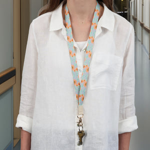 Person wearing a white shirt with a colorful lanyard and keys.
