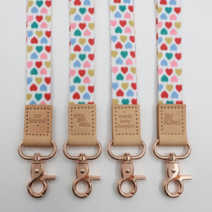 Sweet Hearts lanyards showing Be Kind, Teach Love Inspire, You Got This and So Loved embossed trims and lobster clasps.