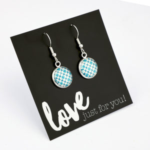 Teal print silver dangle earrings on love and inspiring word card on white background.