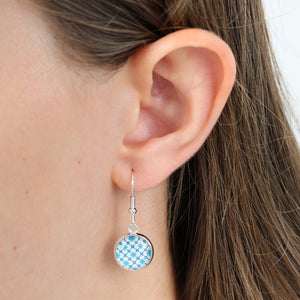 Close-up of an ear wearing a blue patterned earring.