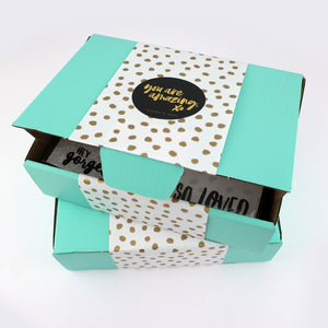 Teal box with gold polka dot pattern and motivational stickers on a white background