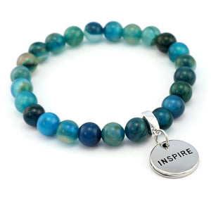 Blue beaded bracelet with a silver 'INSPIRE' charm on a white background