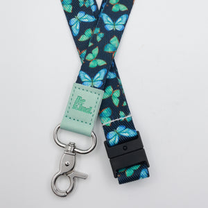 Be Kind embossed on a navy lanyard with teal butterflies and mint trim and a lobster clasp.