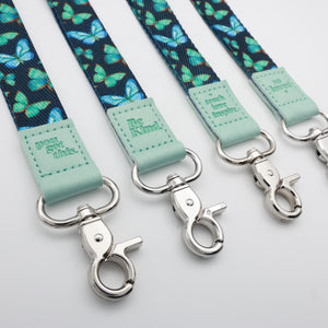 Teal Butterflies lanyards showing Be Kind, Teach Love Inspire, You Got This and So Loved embossed trims and lobster clasps.