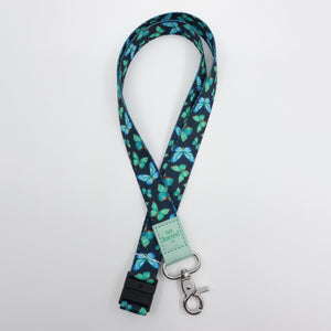 So Loved embossed on a navy lanyard with teal butterflies and mint trim and a lobster clasp.