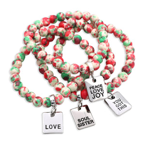 Set of colorful beaded bracelets with motivational charms on a white background