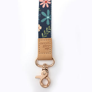 Floral patterned keychain with 'never give up' tag on a white background