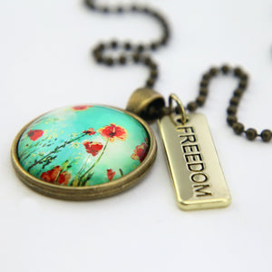 Necklace with floral pendant and 'FREEDOM' tag on a white background