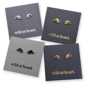 Four pairs of cowgirl hat stud earrings displayed on dark gray backing cards with the phrase "wild at heart." printed on them.