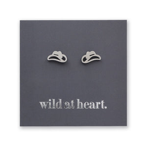 Silver cowgirl hat earrings on a black card with 'wild at heart.' text.