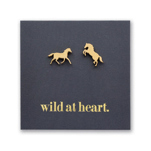 Gold horse earrings on a black card with 'wild at heart.' text