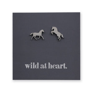 Silver horse earrings on a black card with 'wild at heart.' text
