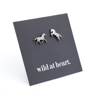 Silver horse earrings on a black card with 'wild at heart.' text