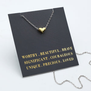 Necklace with a heart pendant on a black card with gold text