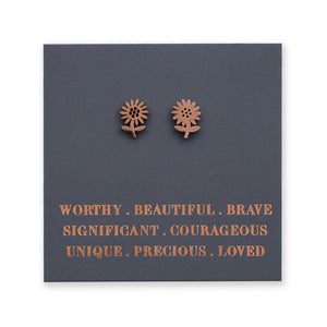 Pair of sunflower-shaped earrings on a dark blue card with motivational text.