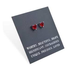 Red heart-shaped earrings on a gray card with motivational text