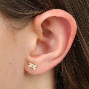 Close-up of an ear wearing a dragonfly-shaped earring.