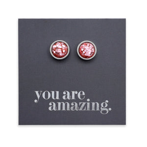 Pink glittery stud earrings on a gray card with 'you are amazing' text