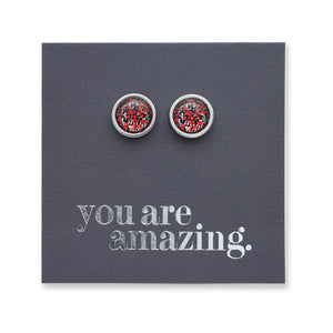 Silver earrings with red gemstones on a card that says 'you are amazing'.