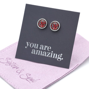 Pair of earrings on a card with 'you are amazing' text, placed on a pink cloth with 'Sister & Soul' branding.