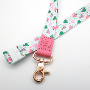 Close-up of the Christmas Delight lanyard with a pink Teach Love Inspire tab, colourful Christmas tree print and gold-tone clasp.
