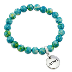 Stone bracelets with blue and green stone beads and silver charms with the words 'strength', 'loved', and 'inspire' on them.