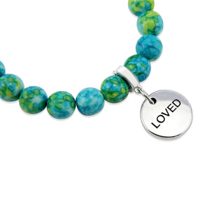 Stone bracelets with blue and green stone beads and silver charms with the words 'strength', 'loved', and 'inspire' on them.