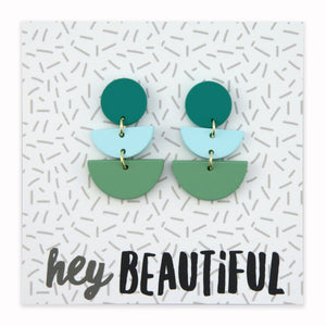 Acrylic and polymer clay statement dangle earrings in shasdes of green on a card that says 'hey beautiful'.