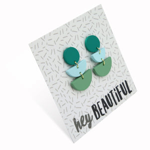 Acrylic and polymer clay statement dangle earrings in shasdes of green on a card that says 'hey beautiful'.