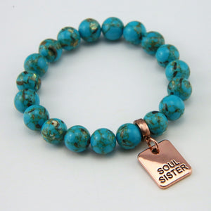 Teal coloured stone bracelet with word charm and rose gold clip.