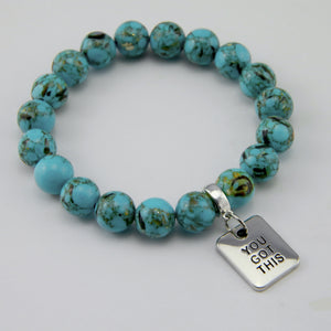 Teal coloured stone bracelet with word charm and silve r clip.