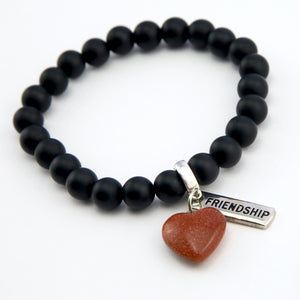 Matt black onyx stone bead bracelet with copper sparkle sandstone heart charm and inspiring word charms in silver.