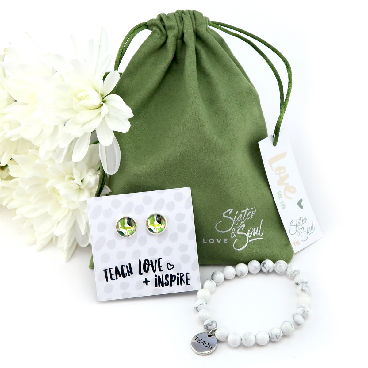 Jewelry set with earrings and bracelet on a white background, featuring a green drawstring bag and white flowers.