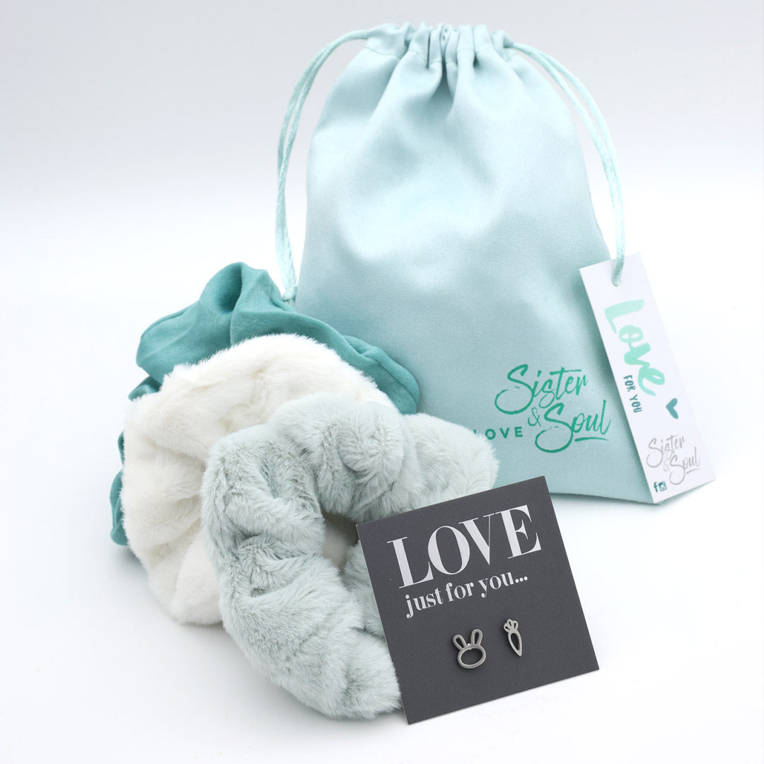 Turquoise and white textured bags with a drawstring bag, card, and tag on a light gray background.